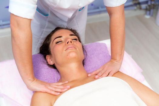 Facial massage. A woman is given a massage in a beauty salon. Close-up.