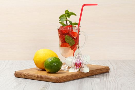 Carbonated lemonade with strawberry slices and mint on an wooden cutting board, Cold beverage for hot summer day