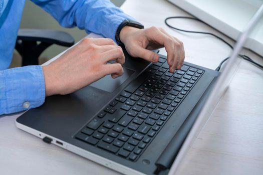 Close up of mans hand typing on laptop keyboard, businessman programmer working concept