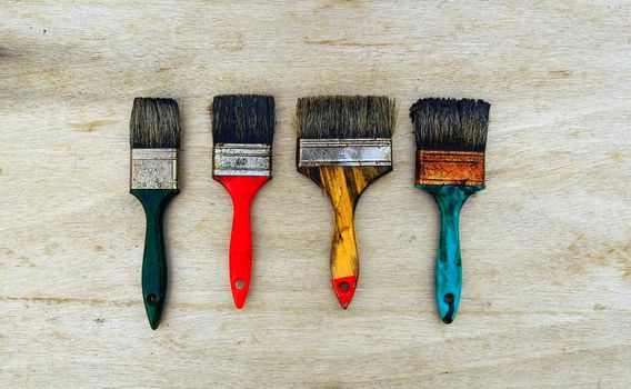 dirty work brushes used for painting on wood, are photographed from above