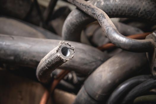 Rubber pipes and hoses leading from the car radiator to the engine, view of the engine from below. old worn rubber car cooling system hoses.