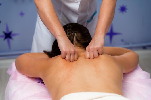 Facial massage. A woman is given a massage in a beauty salon. Close-up