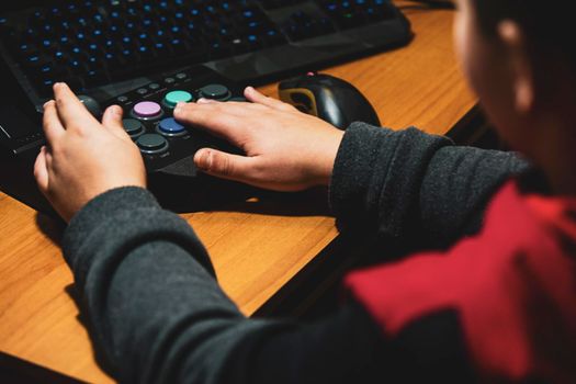 Imperia, Italy, 20/11/2019: hands of a young boy who in the house plays with video games and joystick from vintage arcade