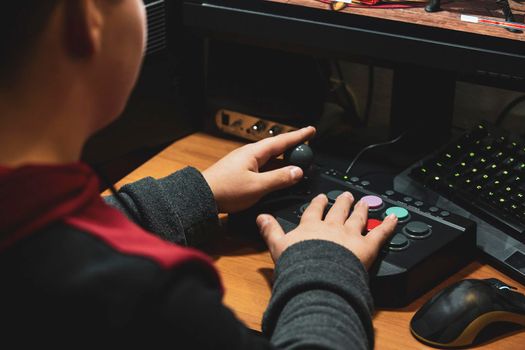 Imperia, Italy, 20/11/2019: hands of a young boy who in the house plays with video games and joystick from vintage arcade