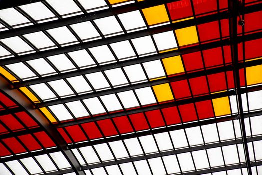 Roof with colored windows of red white and yellow generates a geometric texture