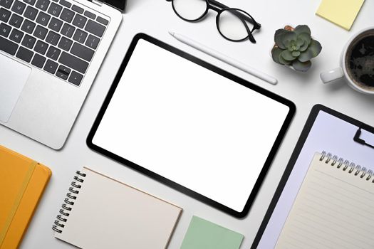 Modern workplace with digital tablet, laptop computer, notebook and glasses. Top view, Flat lay.