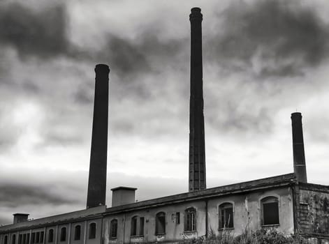 ancient factory with stone towers and dramatic sky