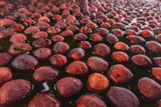 washing red apples in large quantities for further transfer to the packaging line, close-up