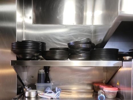 Kitchen shelving with stacked dishes ready for kitchen service