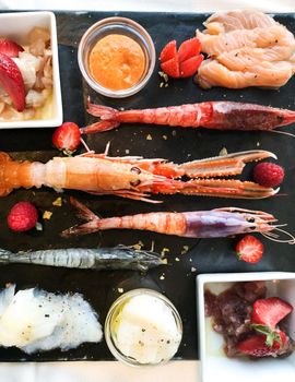 fresh fish with sauces photographed from above and laid its dark stone