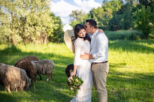 Full length body portrait of young bride and groom enjoying romantic moments outside at sunset in beautiful summer day. Wedding couple. Standing face to face with the green hills on background