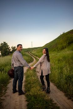 Young couple in Ukrainian style clothing walking along the road.