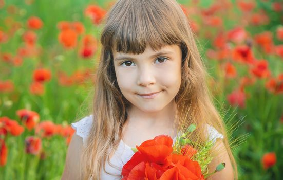 children girl in a field with poppies. selective focus.