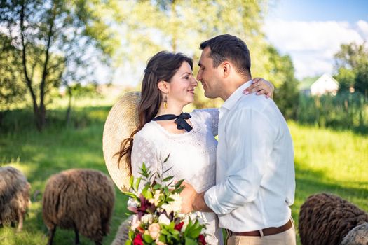 a wedding couple of lovers, the bride and groom, are standing in the middle of beautiful green hills.