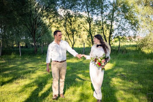 nice portrait of beautiful and young groom and bride outdoors