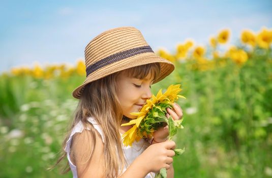 A child in a field of sunflowers. Selective focus.