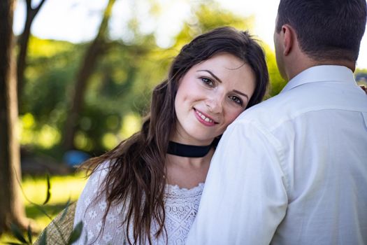 Portrait of a happy bride and groom, in boho style wedding dresses, against the backdrop of beautiful nature.