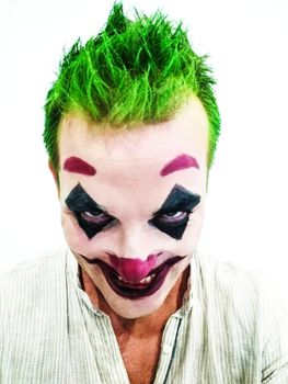 cosplay masquerading as joker, the famous comic book villain, frontal view of the actor.