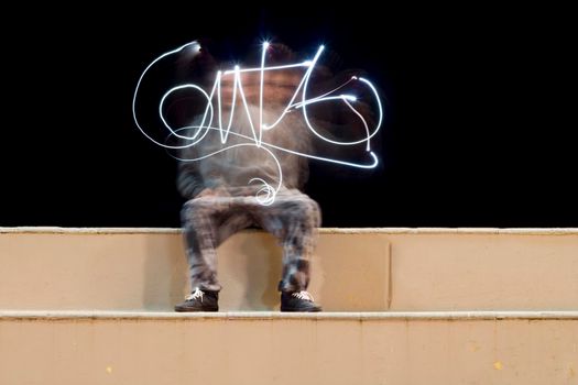 One person creates a signature made with the technique of light painting.