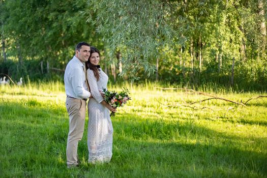 young wedding couple - freshly wed groom and bride posing outdoors on their wedding day color toned image.