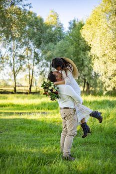 stylish groom picking up his gorgeous bride at sandy beach lake, true emotions.