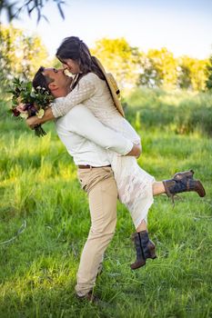 the groom holds the bride in his arms