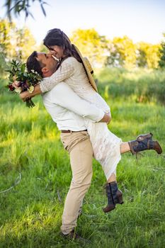 the groom holds the bride in his arms