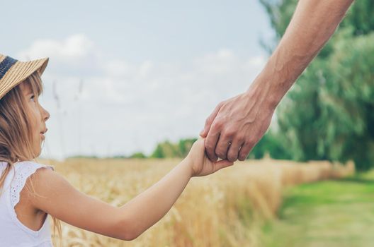 Child and father in a wheat field. Selective focus.