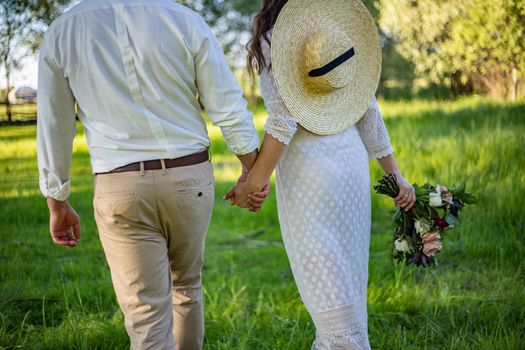 portrait of a girl and couples looking for a wedding dress, a pink dress flying with a wreath of flowers on her head on a background tsvetu chicago garden and the blue sky, and they hug and pose.