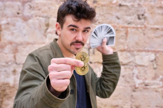 Portrait of a male street magician performing magic tricks with cards and cryptocurrencies