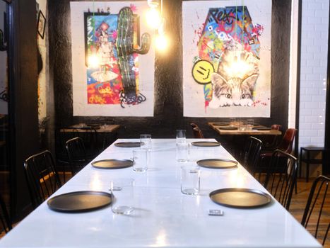 Restaurant table ready to eat with contemporary paintings in the background