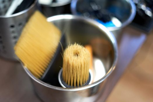 Selective focus on two barber brushes of different sizes in a stain pan in a barber shop