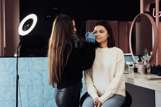 Female Master Combs Eyebrow to Young Woman, Process of Cleaning Procedure at Beauty Salon