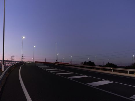 Curvy highway at night illuminated by streetlights
