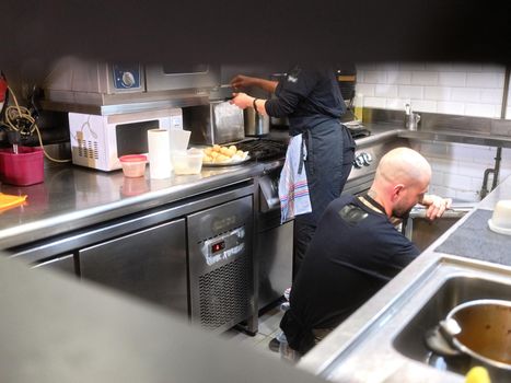 Work team in unifrom working on the kitchen of a restaurant