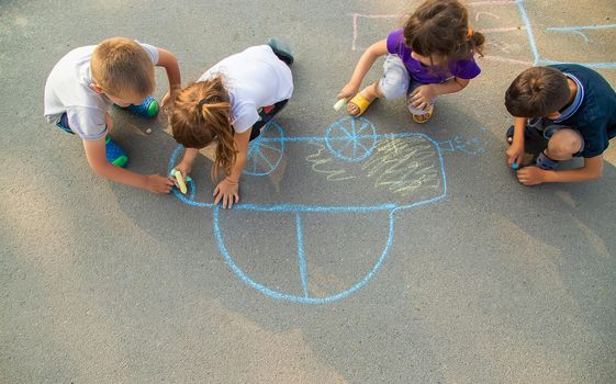 children draw a car with chalk on the pavement. selective focus. nature.