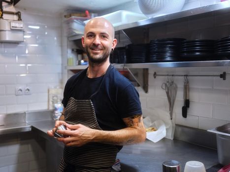 Portrait of a cook with a modern look standing on a clean kitchen of a restaurant