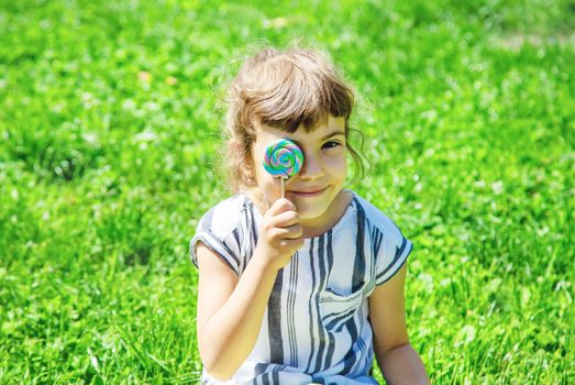 child eats lollipop on nature. Selective focus.