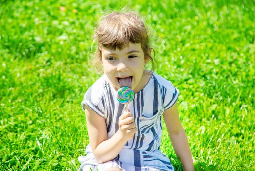 child eats lollipop on nature. Selective focus.