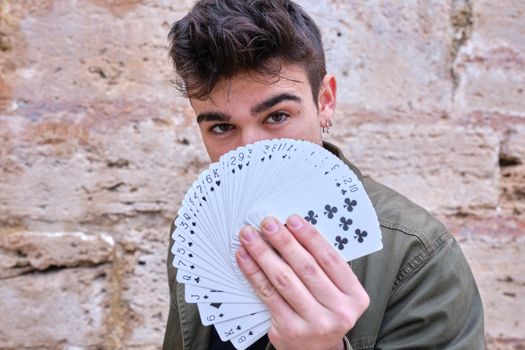 Street magician showing poker cards in his hand in the shape of a fan