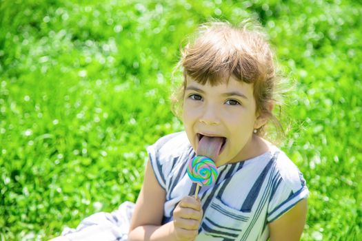 child eats lollipop on nature. Selective focus.