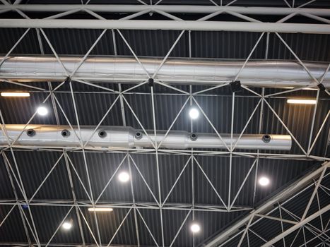 Ceiling of an industrial building with security system and piping hanging on it