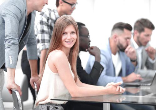 A group of business people listening to a colleague, addressing an office meeting