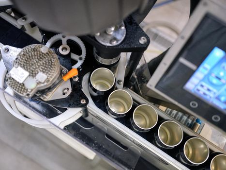 Top view of a raw of craft beer cans in a production line of a bottling factory