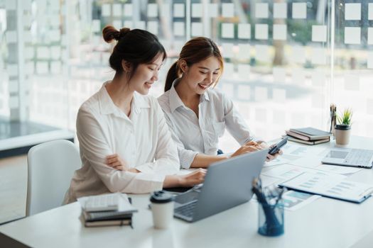 financial, Planning, Marketing and Accounting, portrait of Asian woman Economist using calculator to calculate investment documents with partners on profit taking to compete with other companies.