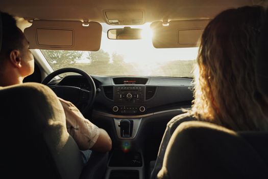 Back View of Woman and Man Traveling by Car, Young Couple on Road Trip at Sunset