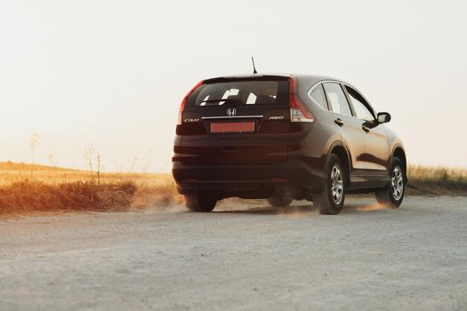 TERNOPIL, Ukraine - July 21 2021: Back View of Honda CR-V Riding on Country Road at Sunset