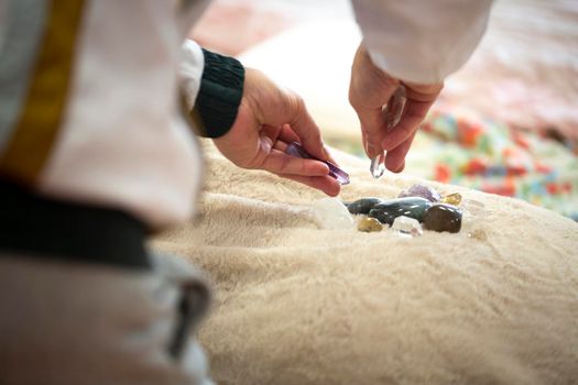 Reiki therapy session with stones that absorb and mutate the energy of the body