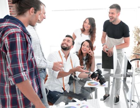 group of editors discussing the color palette of sitting behind a Desk.