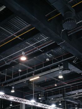 Vertical photo of the ceiling of a trade fair with pipes and safety system tools